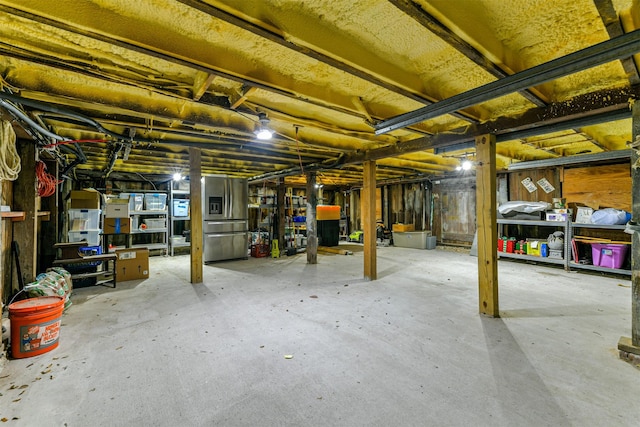 basement with stainless steel fridge with ice dispenser