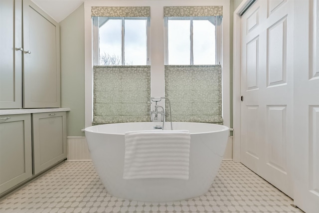 bathroom with a healthy amount of sunlight and a tub to relax in