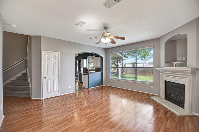 unfurnished living room featuring ceiling fan and hardwood / wood-style flooring