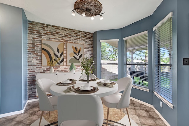 dining room featuring brick wall