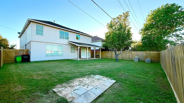 rear view of property featuring a yard and a patio