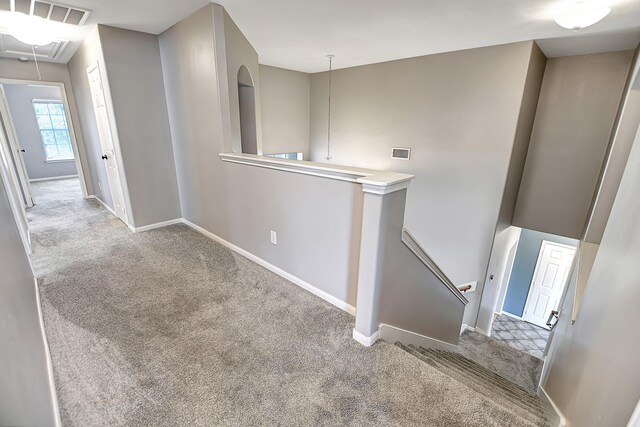 hallway featuring light colored carpet