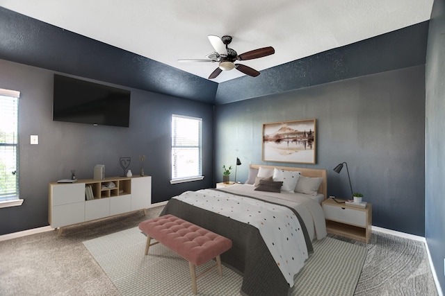 carpeted bedroom with ceiling fan and vaulted ceiling