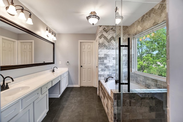 bathroom featuring a relaxing tiled tub, tile patterned floors, a wealth of natural light, and vanity