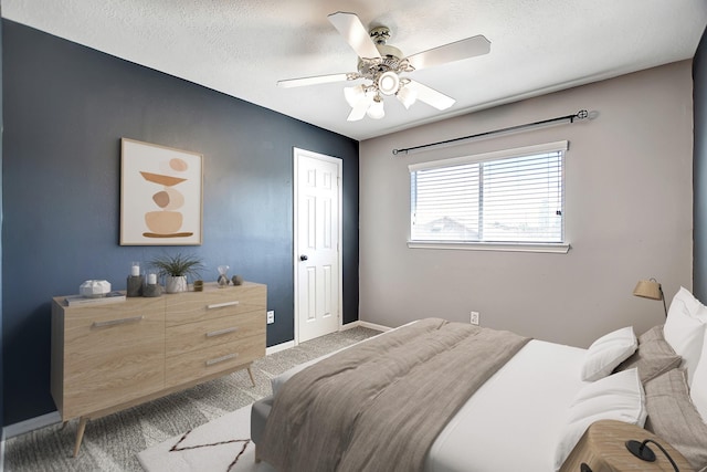 carpeted bedroom featuring ceiling fan, a closet, and a textured ceiling