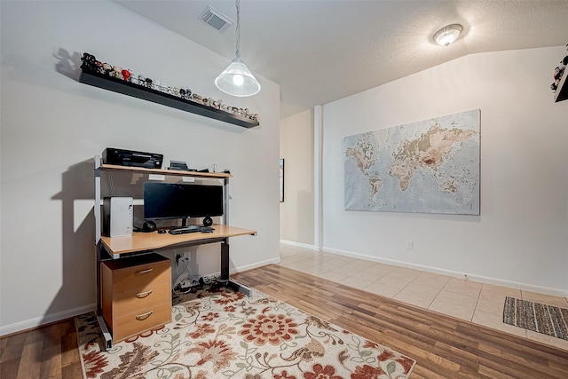 home office with lofted ceiling, a textured ceiling, and hardwood / wood-style floors