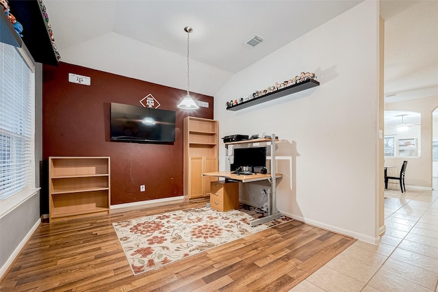 office area featuring light wood-type flooring, vaulted ceiling, and a healthy amount of sunlight