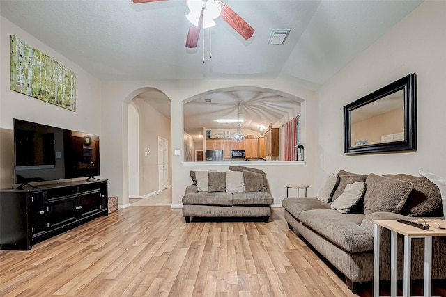 living room featuring light hardwood / wood-style floors and ceiling fan with notable chandelier