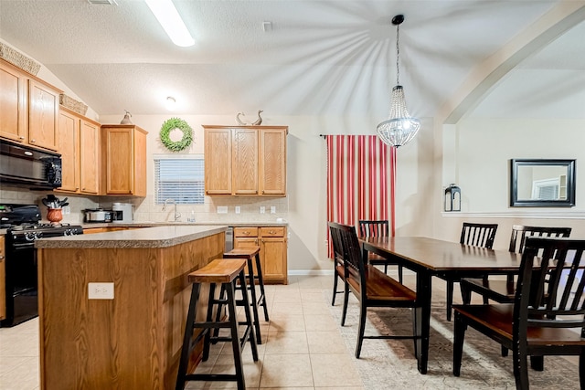 kitchen with black appliances, a center island, pendant lighting, sink, and lofted ceiling