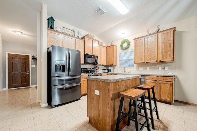 kitchen with vaulted ceiling, a center island, stainless steel refrigerator with ice dispenser, a kitchen bar, and backsplash