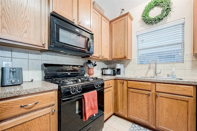 kitchen featuring light tile patterned floors, black appliances, decorative backsplash, and sink