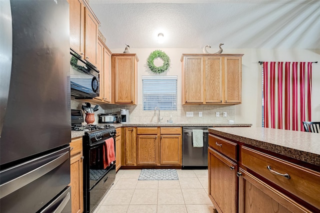 kitchen with sink, light tile patterned floors, backsplash, and black appliances