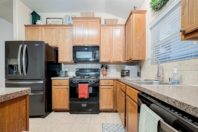 kitchen featuring sink, vaulted ceiling, light tile patterned floors, backsplash, and black appliances