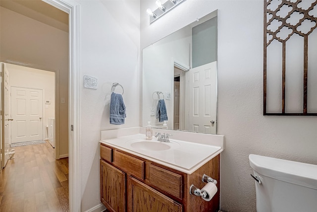 bathroom featuring toilet, wood-type flooring, and vanity