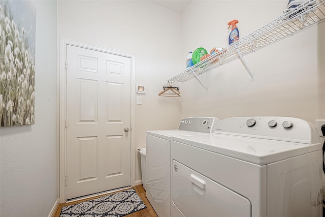 laundry area featuring separate washer and dryer and light hardwood / wood-style flooring