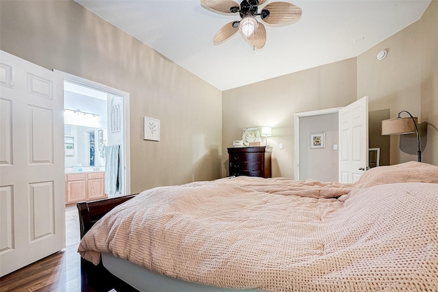 bedroom with ensuite bath, ceiling fan, vaulted ceiling, and dark wood-type flooring