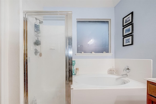 bathroom featuring plus walk in shower and vanity