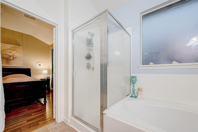 bathroom with separate shower and tub, vaulted ceiling, and tile patterned floors