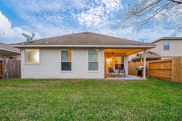 back of house featuring a lawn and a patio