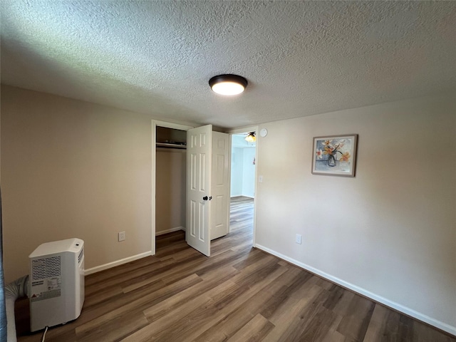 unfurnished bedroom featuring wood-type flooring, a closet, and a textured ceiling