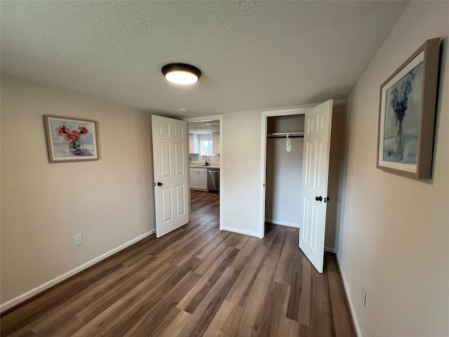 unfurnished bedroom featuring hardwood / wood-style flooring, a textured ceiling, and a closet