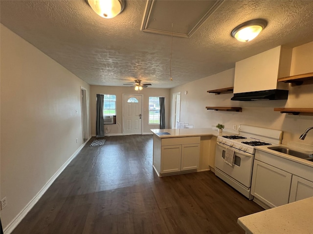 kitchen with kitchen peninsula, dark hardwood / wood-style floors, white range with gas cooktop, white cabinets, and sink