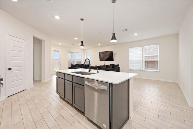 kitchen featuring a center island with sink, dishwasher, hanging light fixtures, and sink