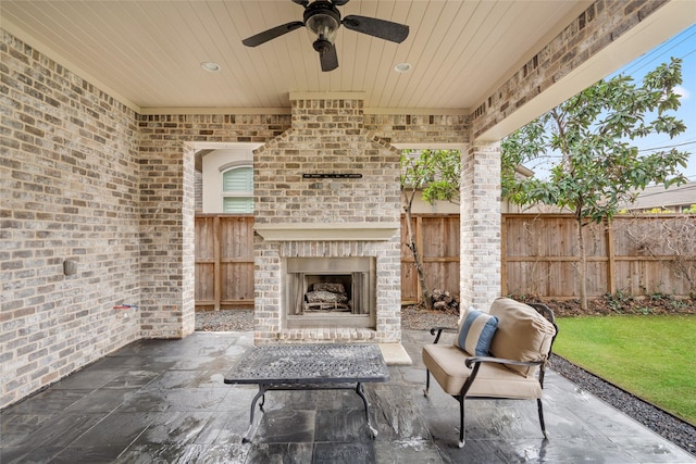 view of patio / terrace featuring an outdoor brick fireplace and ceiling fan