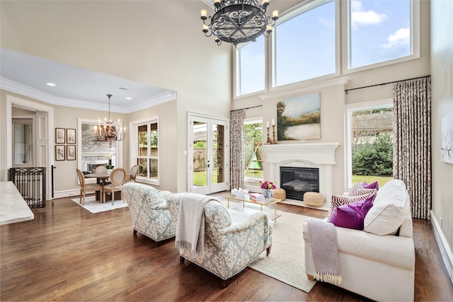 living room with dark hardwood / wood-style flooring, a notable chandelier, crown molding, and french doors