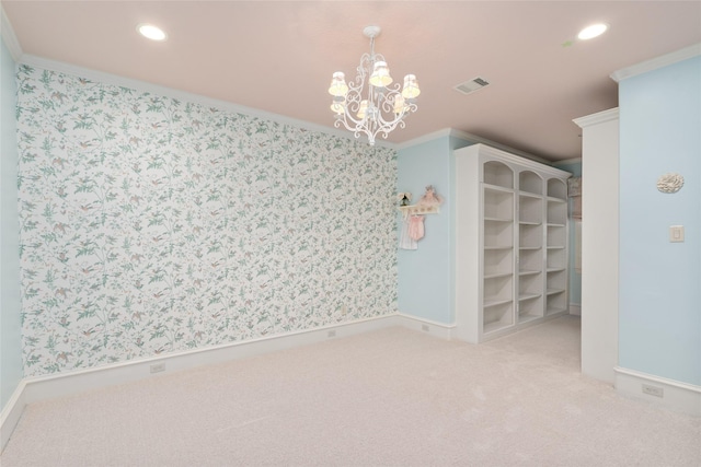 carpeted empty room featuring a notable chandelier and ornamental molding