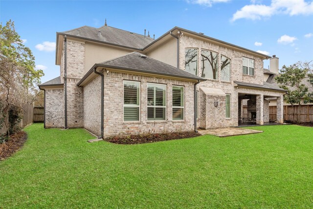 rear view of property featuring a yard and a patio area