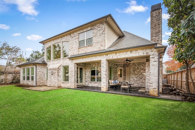 rear view of house with ceiling fan, a yard, and a patio