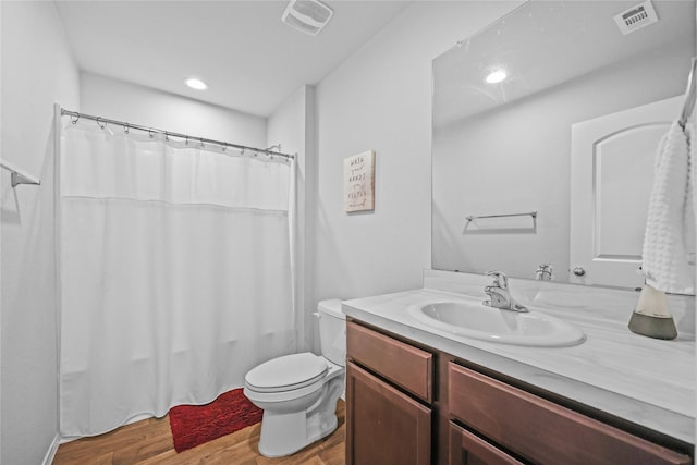 bathroom featuring toilet, wood-type flooring, and vanity