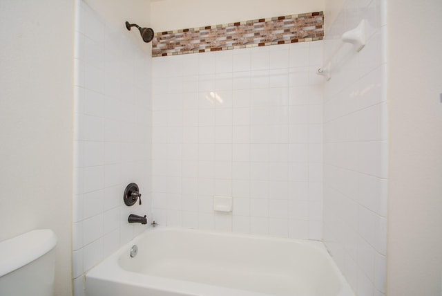 bathroom with toilet and tiled shower / bath combo