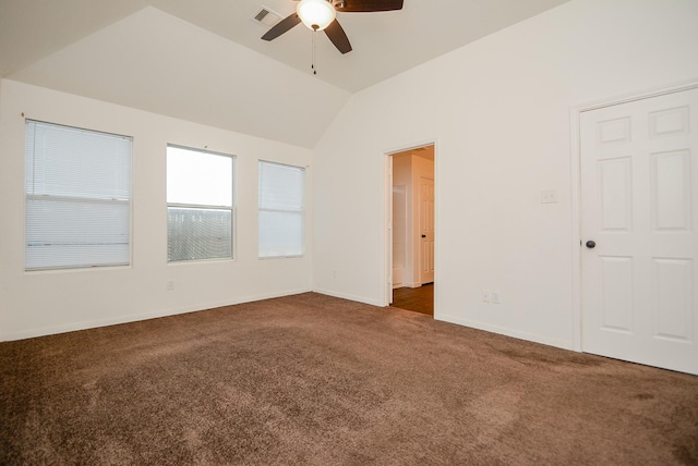 spare room featuring lofted ceiling, dark colored carpet, and ceiling fan