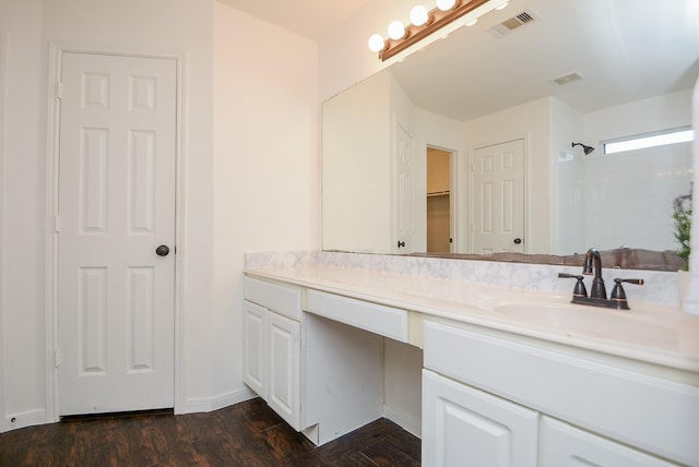 bathroom with a shower, wood-type flooring, and vanity