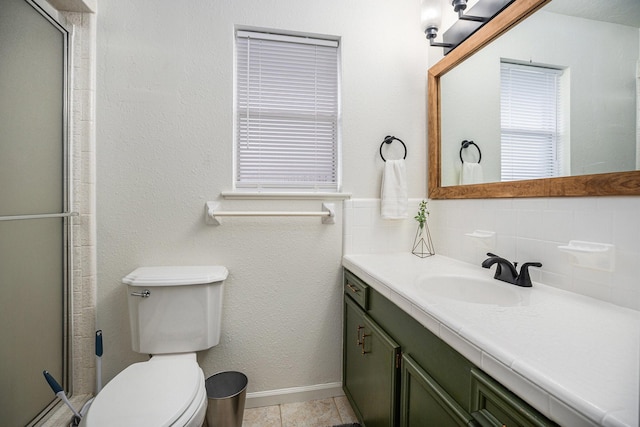 bathroom with toilet, vanity, backsplash, tile patterned floors, and an enclosed shower