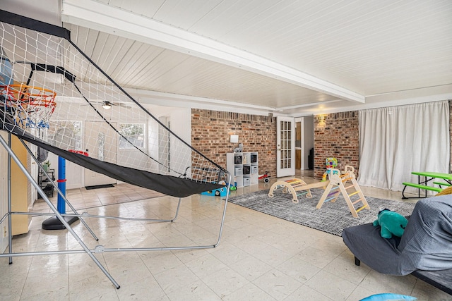 recreation room with brick wall and beamed ceiling