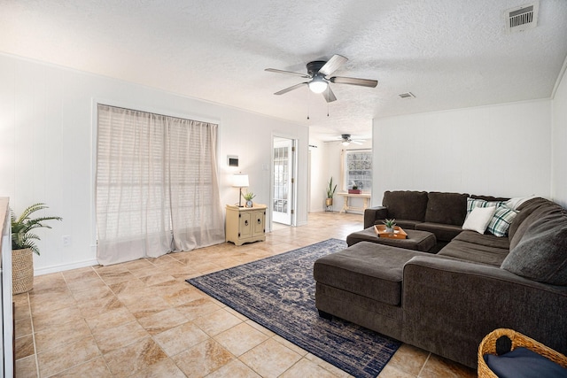 living room with a textured ceiling and ceiling fan