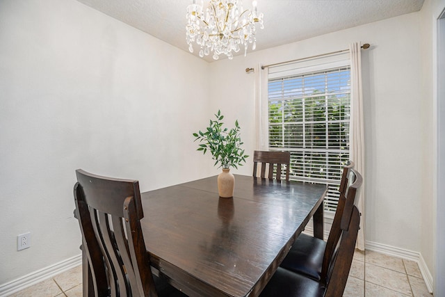 dining area featuring light tile patterned floors, an inviting chandelier, and a textured ceiling