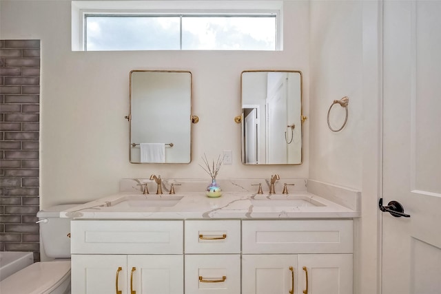 bathroom with toilet, vanity, and a healthy amount of sunlight