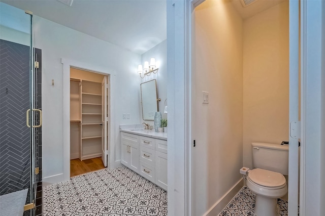 bathroom featuring toilet, tile patterned flooring, walk in shower, and vanity