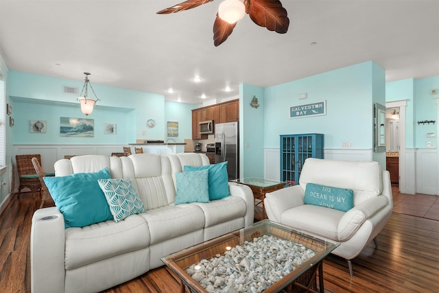 living room with dark wood-type flooring and ceiling fan