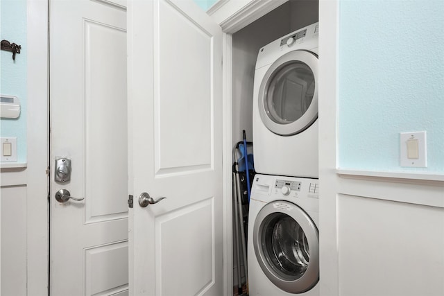 clothes washing area featuring stacked washer / dryer