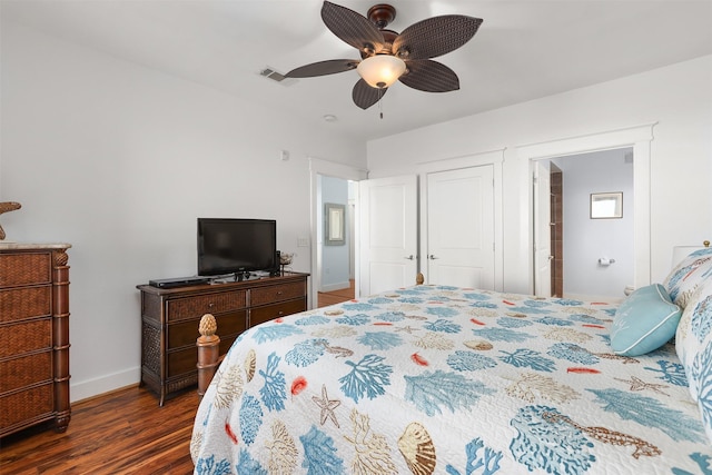 bedroom featuring ceiling fan, dark hardwood / wood-style floors, and connected bathroom