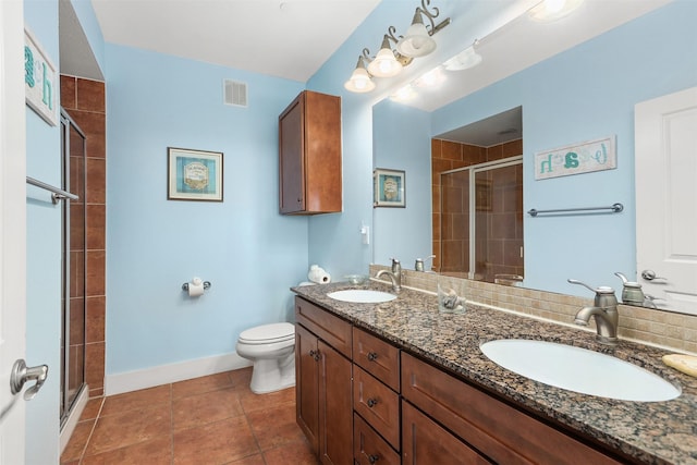 bathroom with toilet, vanity, tile patterned floors, and a shower with shower door