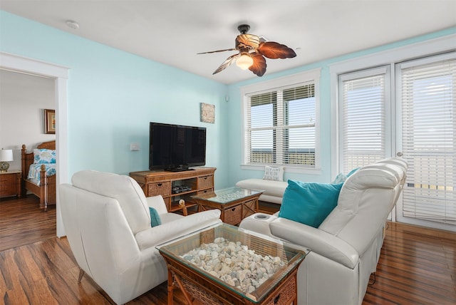 living room featuring ceiling fan and dark hardwood / wood-style flooring