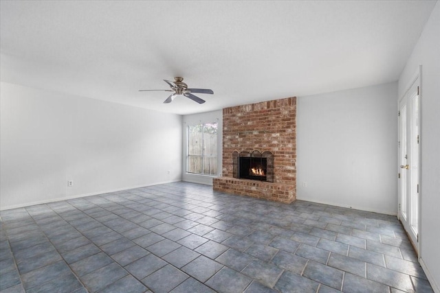 unfurnished living room with ceiling fan and a brick fireplace