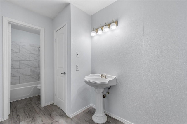 bathroom featuring tiled shower / bath and wood-type flooring