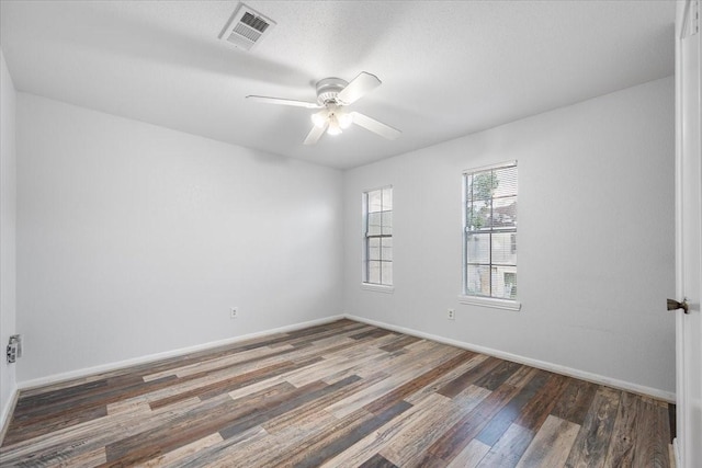 unfurnished room with ceiling fan and dark hardwood / wood-style flooring